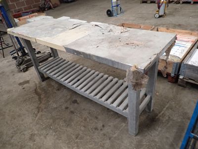 a table with a shelf on it in the middle of a warehouse