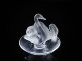 une sculpture en verre transparent représentant deux canards sur une assiette