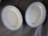 two white plates with blue rims are sitting on a table