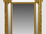 an ornate gold framed mirror on a white wall