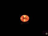un gros plan sur un diamant orange dans l'obscurité