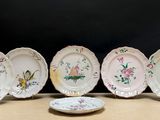 quatre assiettes ornées de fleurs et d'oiseaux sont posées sur une table