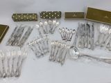 a lot of silverware sitting on a white table