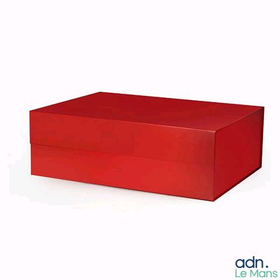 une boîte rouge posée sur une surface blanche