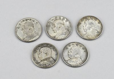quatre types différents de pièces d'argent sur une surface blanche