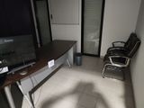 un bureau avec un écran et une chaise dans une pièce