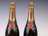two bottles of champagne are sitting on a white surface