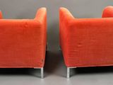 pair of orange velvet lounge chairs with chrome legs