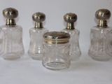 three small glass jars with silver lids and a silver top