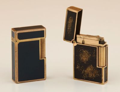 deux briquets noirs et dorés posés l'un à côté de l'autre sur une surface blanche