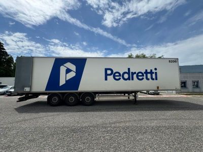 a white semi truck with a blue and white logo parked in a parking lot