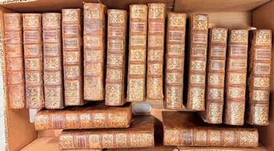 de nombreux vieux livres dans un carton posé par terre