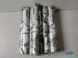 three rolls of fabric with different designs on them sitting on a table
