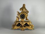une horloge en or surmontée d'une statue