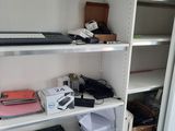 une étagère blanche sur laquelle se trouvent un ordinateur portable et d'autres appareils électroniques