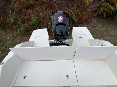 a white boat with a motor on the back of it
