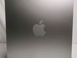 an apple computer sitting on top of a white table next to a white wall