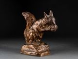bronze sculpture of a squirrel on a rock on a black background