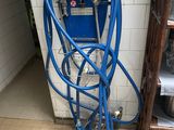 un tuyau bleu relié à une machine bleue dans une pièce