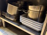 de nombreuses casseroles et poêles sur l'étagère de la cuisine