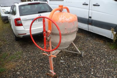 une borne d'incendie orange posée sur un chariot, à côté d'une camionnette blanche