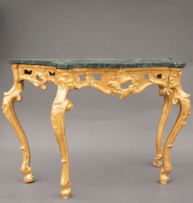 une console richement sculptée, dotée d'un plateau en marbre vert