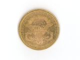 a gold coin with an eagle on it on a white surface