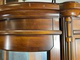 a large wooden cabinet with a mirror on top of it