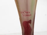a glass vase with a red rose on it on a table
