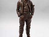 a bronze statue of a man in a hat and jacket