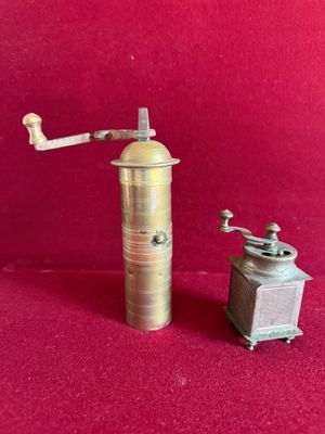 an old coffee grinder and a small coffee grinder on a red background