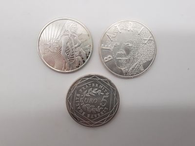 trois types de pièces différents sur une surface blanche