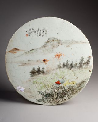 une assiette blanche décorée d'une peinture, posée sur une table