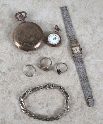 une montre, un bracelet, une bague et d'autres bijoux par terre