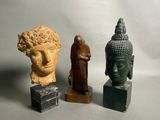 Trois statues de Bouddha sont assises les unes à côté des autres sur des blocs de marbre