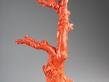 an orange sculpture of a tree with a bird on it
