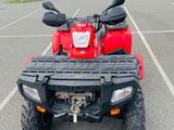 an image of a red four wheeler atv parked in a parking lot