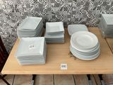 a lot of plates on a table with a price tag on it
