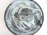a close up of a plate with a face on it