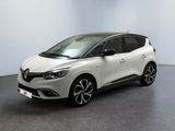 Une voiture blanche est garée dans une pièce au sol noir.