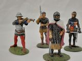 three figurines of men dressed in medieval clothing and holding swords