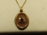 a gold necklace with a bee on it sitting on top of a white box