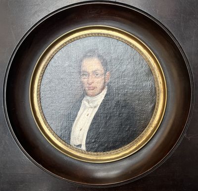 portrait of a man in a tuxedo in a gold frame