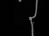 a close up of a necklace and earrings on a black background