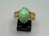 l'image d'une bague en or contenant une pierre verte