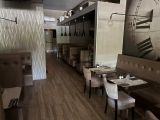 la salle à manger d'un restaurant, avec des tables, des chaises et une horloge accrochée au mur