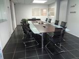 tables and chairs in a conference room with a skylight above them
