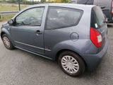 a small grey car parked in a parking lot