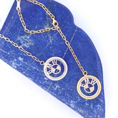 two necklaces on a blue stone with a tree of life symbol
