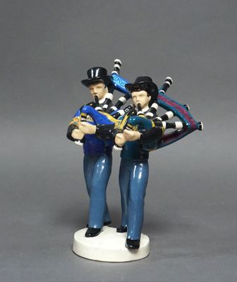 une figurine représentant un homme et une femme tenant une cornemuse